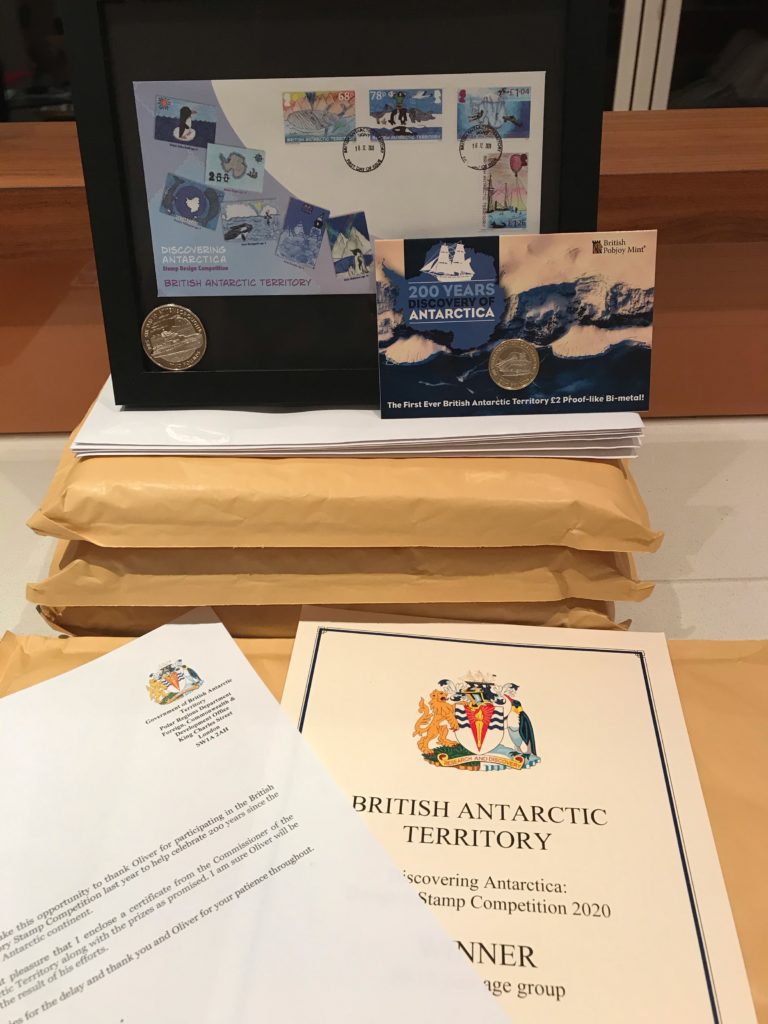 Prizes awarded to BAT Stamp Competition Winners: a framed First Day Cover, a commemorative coin set, a letter and a certificate.